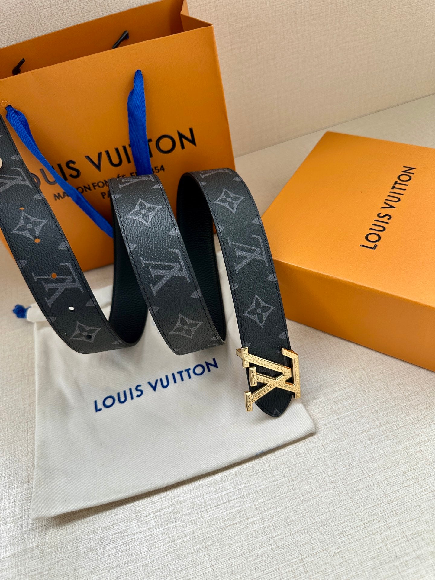 Louis Vuitton belt with dark monogram canvas and gold LV buckle, looped