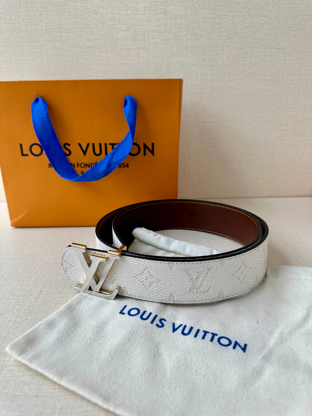 White monogram belt with gold-tone LV buckle and dark brown inner leather