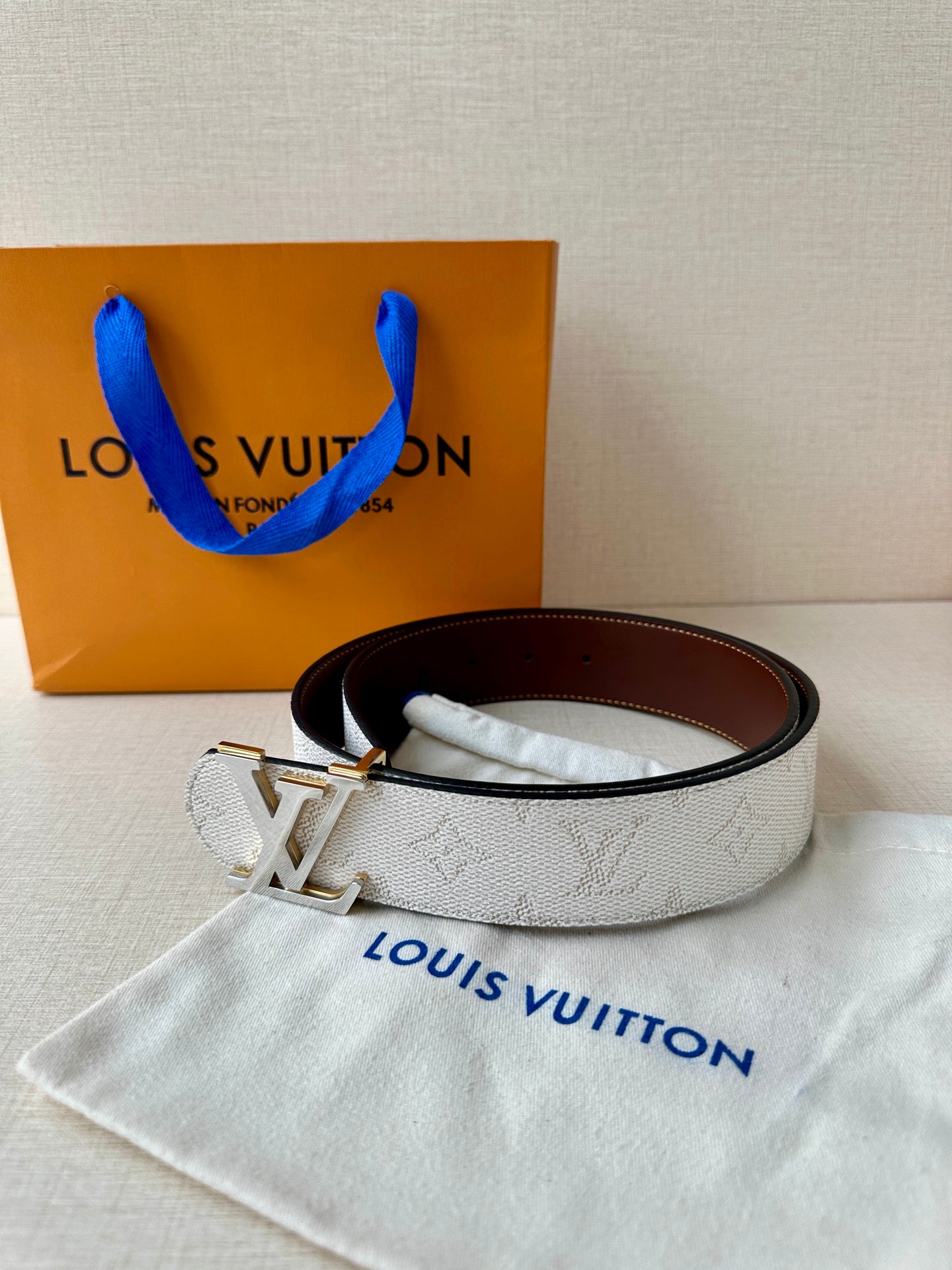 White monogram belt with gold-tone LV buckle and dark brown inner leather