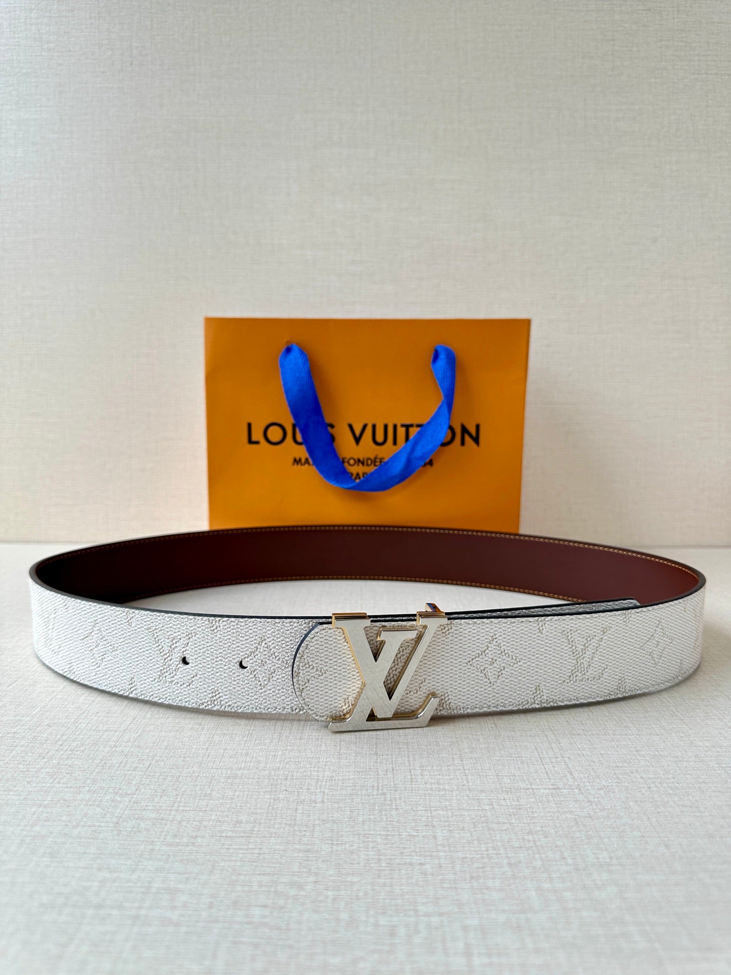 White monogram belt with gold-tone LV buckle and dark brown leather backing