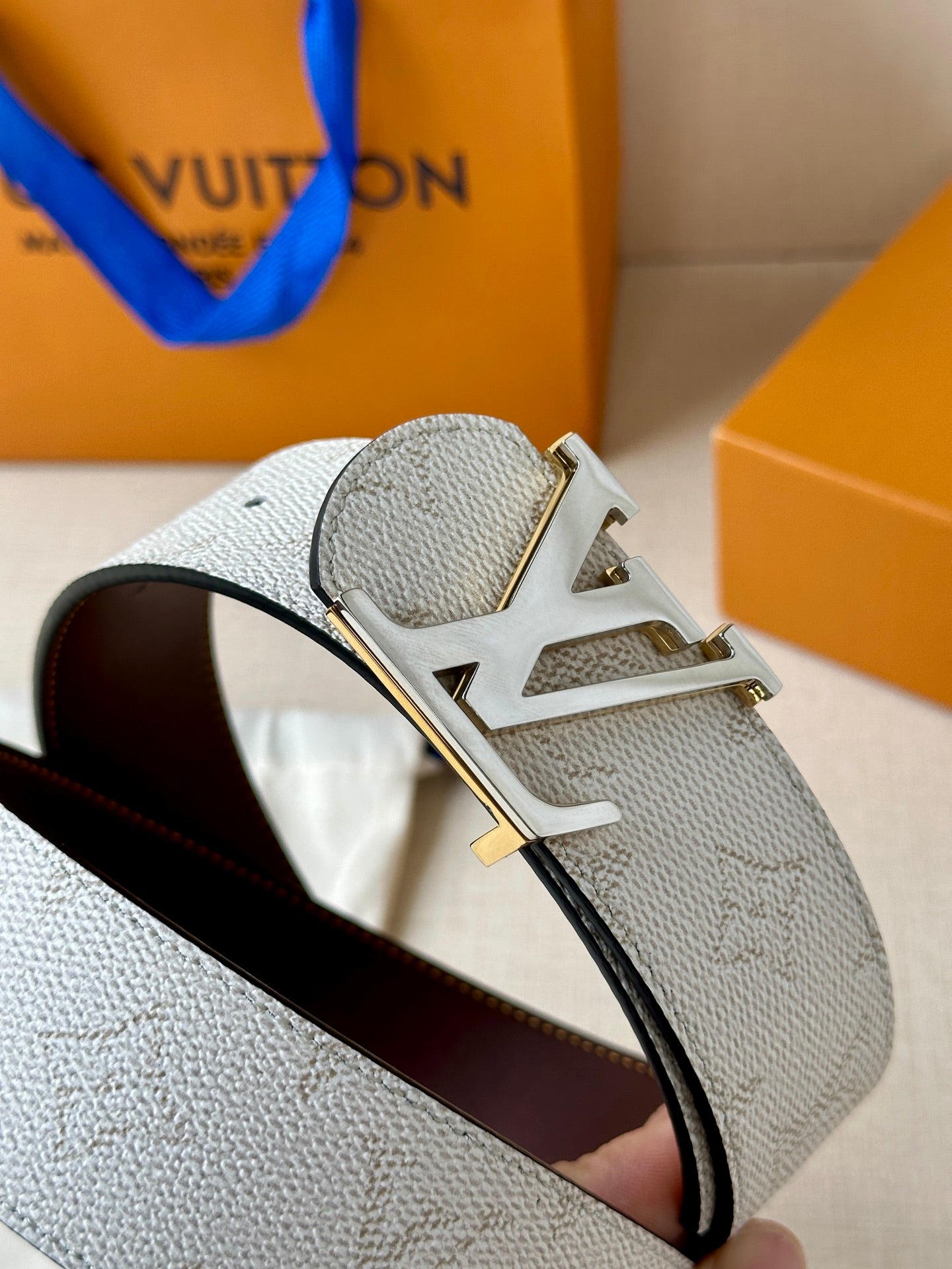 White monogram belt with gold-tone LV buckle and dark brown inner strap