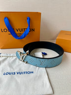 Louis Vuitton belt on dust bag, blue monogram strap with gold LV buckle and black trim.