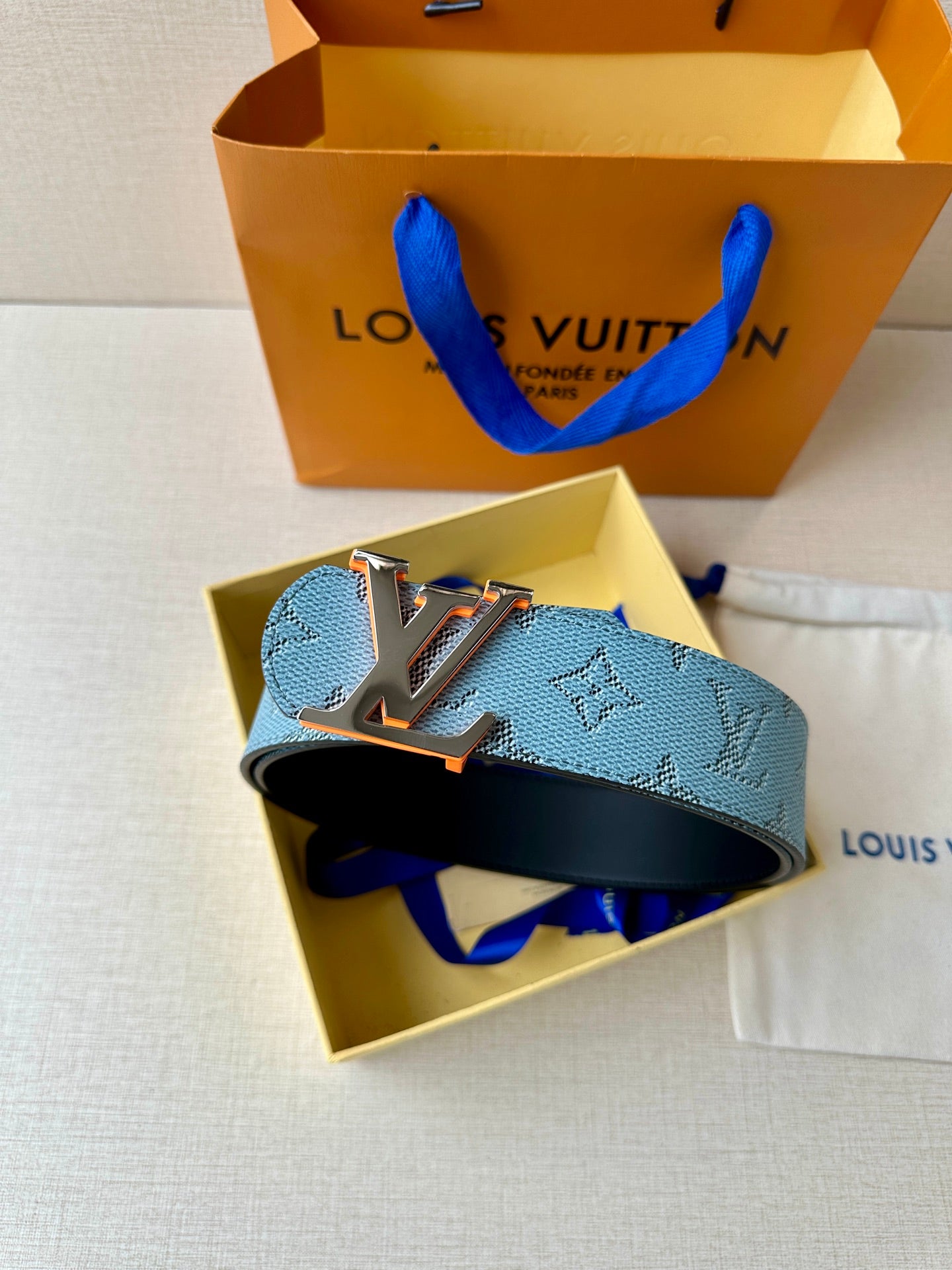 Light blue monogram belt with LV logo buckle, displayed in open box