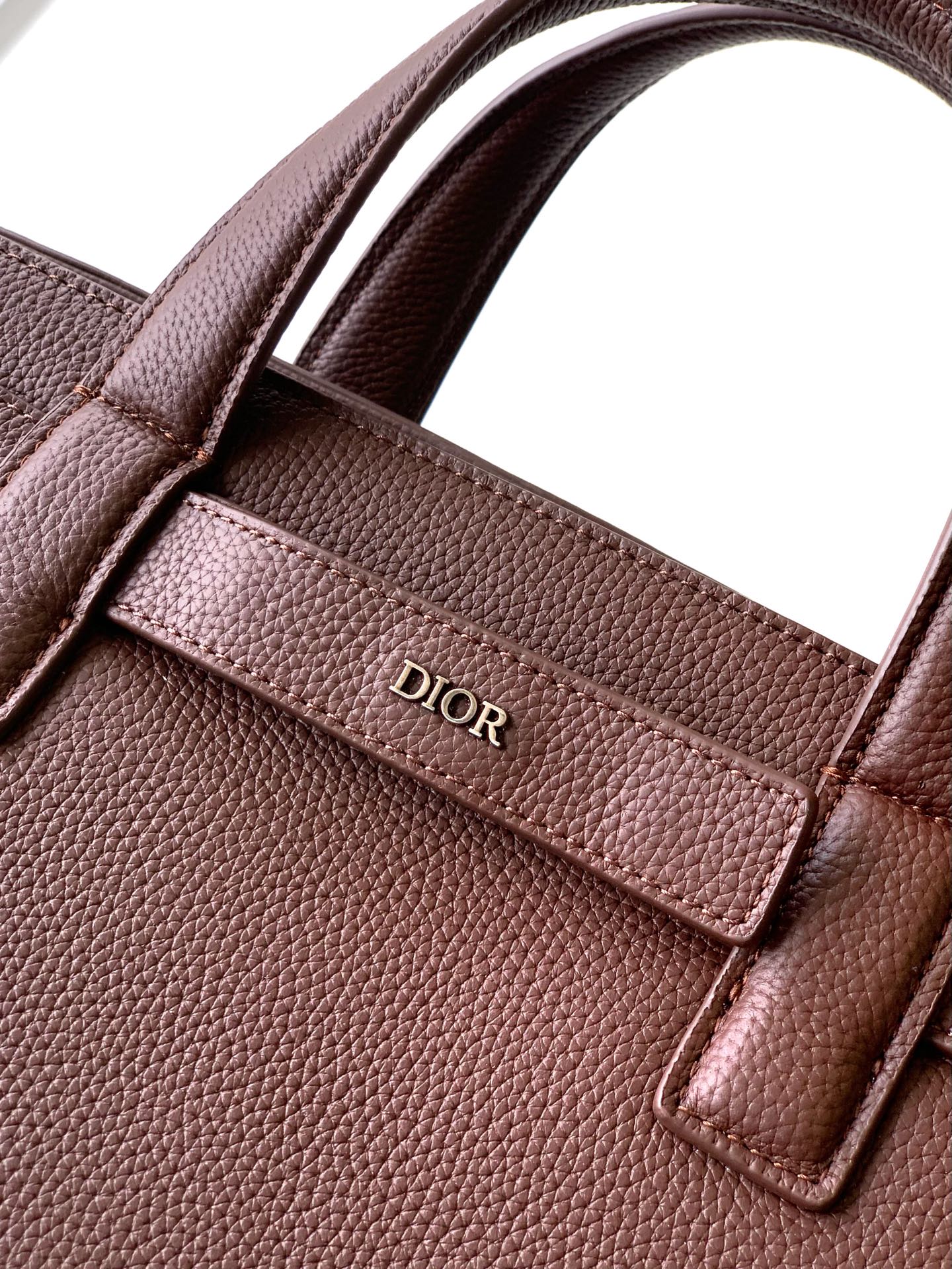 Brown textured leather bag with Dior logo on front pocket