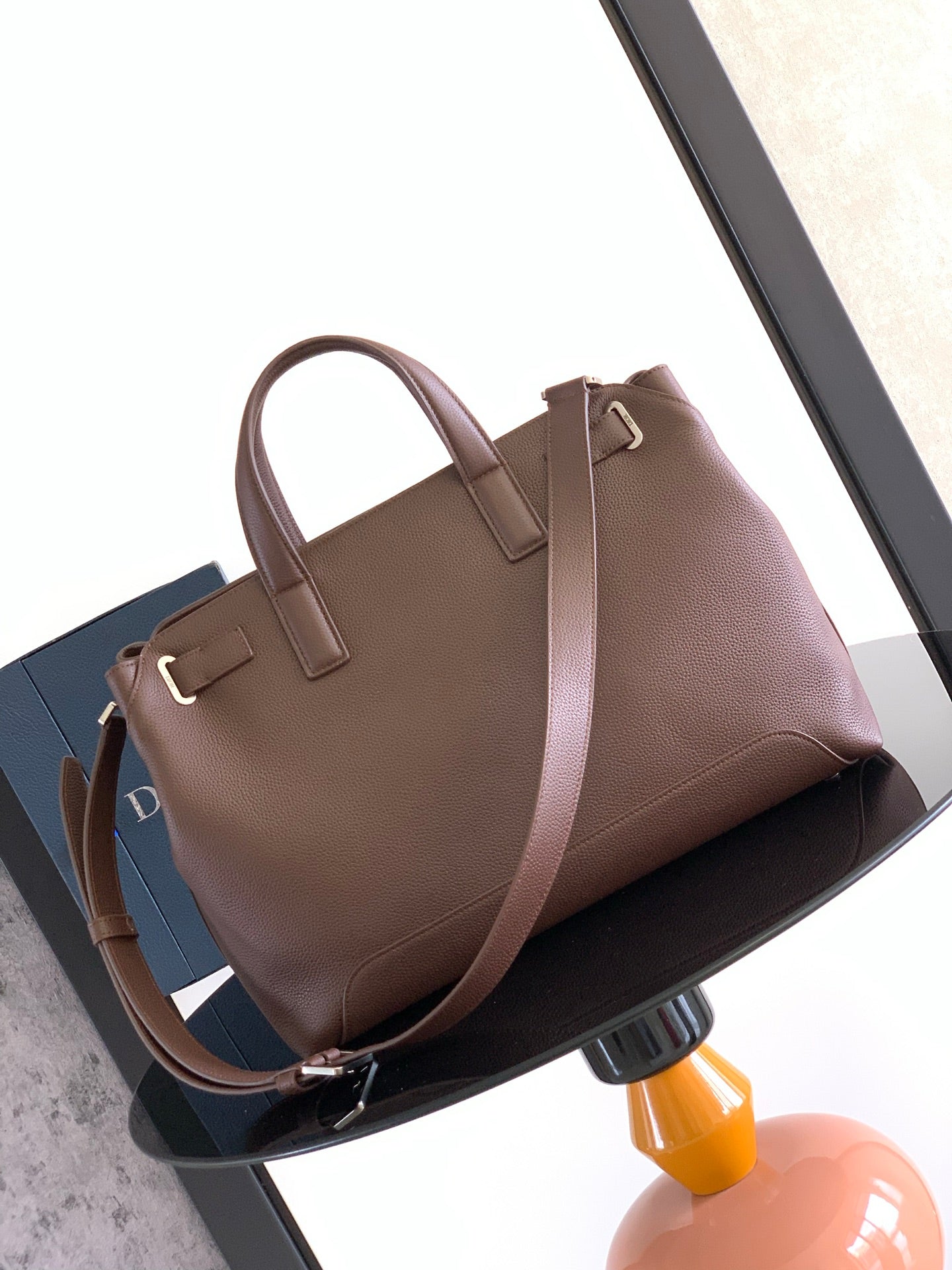 Dior men's brown leather tote bag with dual handles and structured top opening