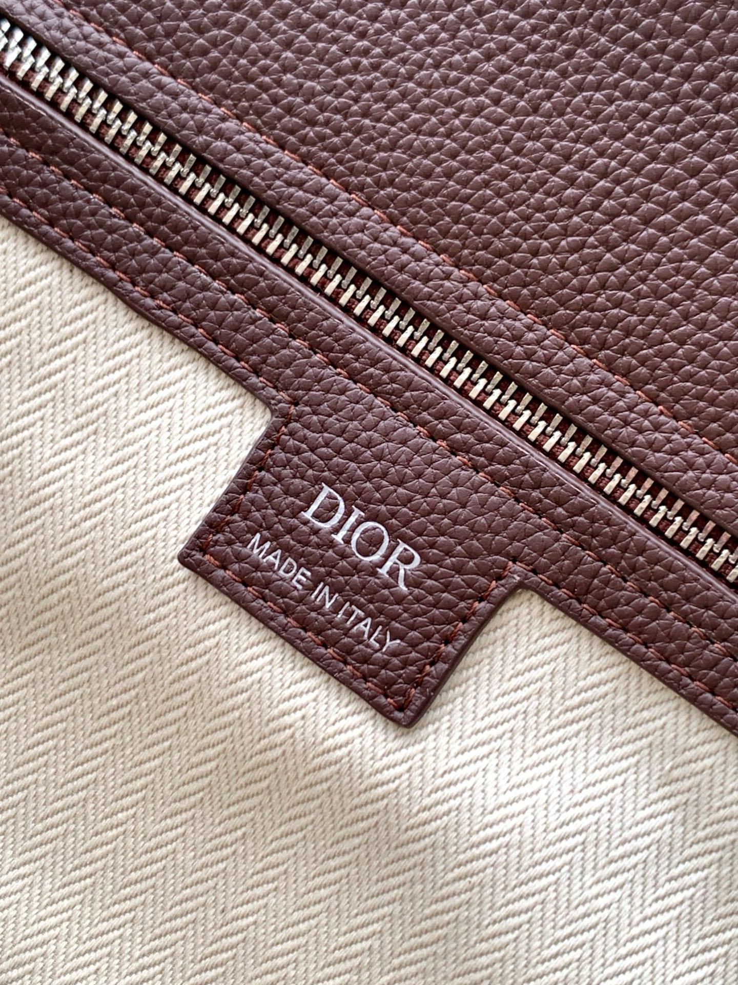 Dior men's brown leather bag Made in Italy label near zipper and pull tab
