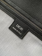 Dior men’s leather bag tag reading “Dior Made in Italy”