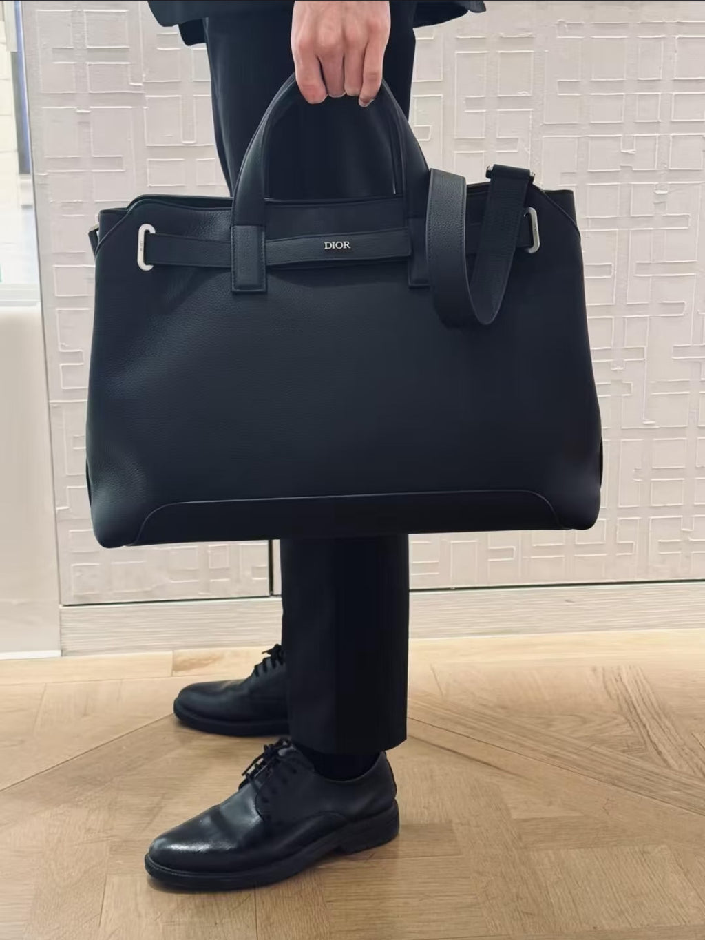 Dior structured tote bag with top handles and front logo, angled view