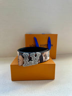 Designer belt with brown-and-beige camo strap and large silver-toned buckle