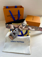 Louis Vuitton belt with camo strap and silver-toned ornate buckle, shown on dust bag
