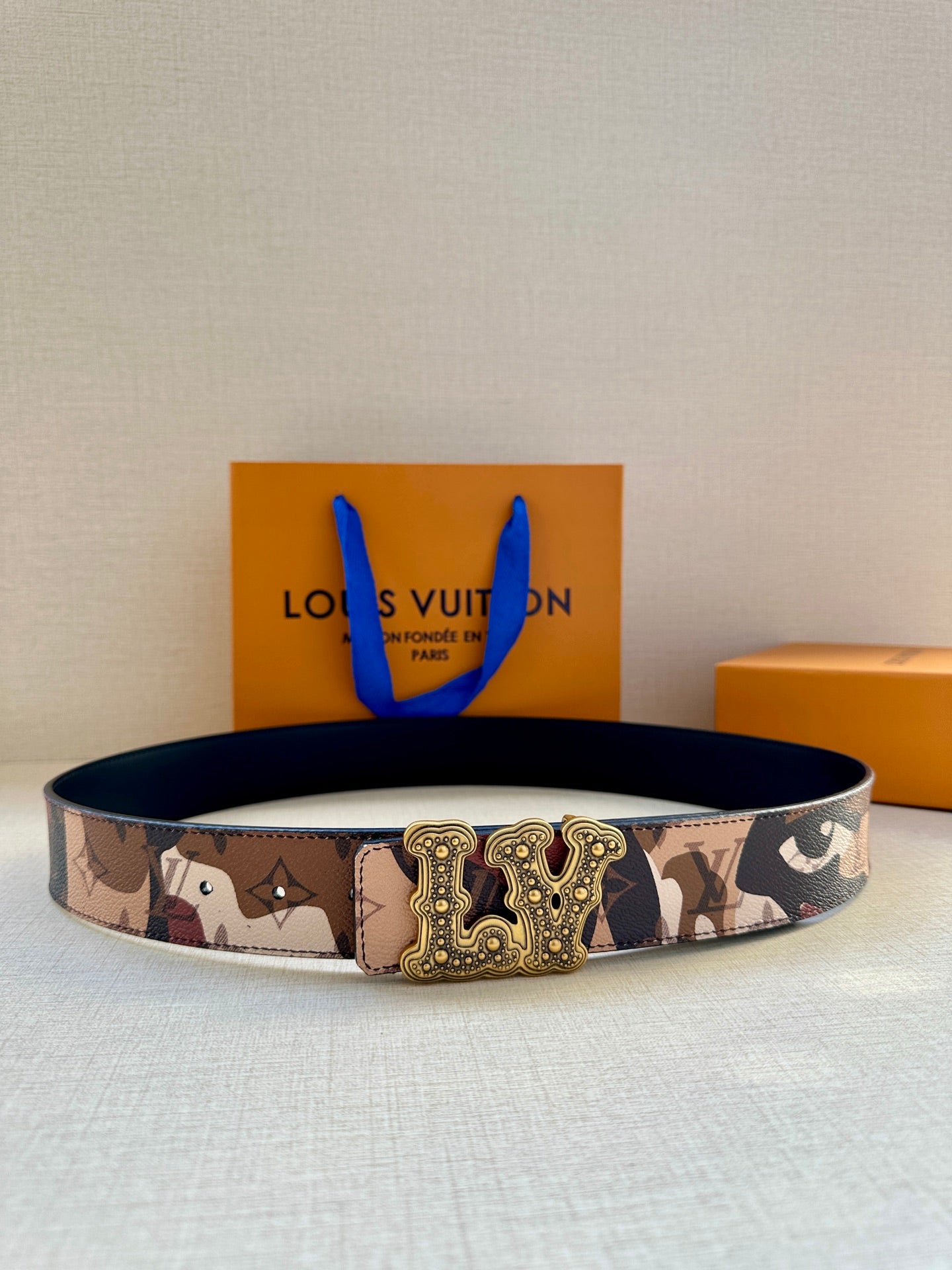 Louis Vuitton belt with brown camo canvas strap and gold-tone ornate buckle