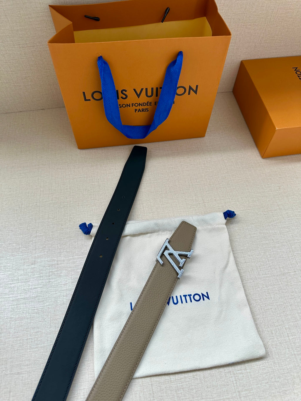 Louis Vuitton belt with beige leather and gold LV buckle, shown with storage pouch