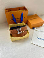 Leather belt with brown strap and silver LV buckle, in open box.