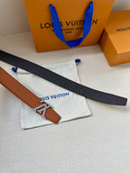 Brown and black belt straps with silver LV buckle, laid on dust bags.
