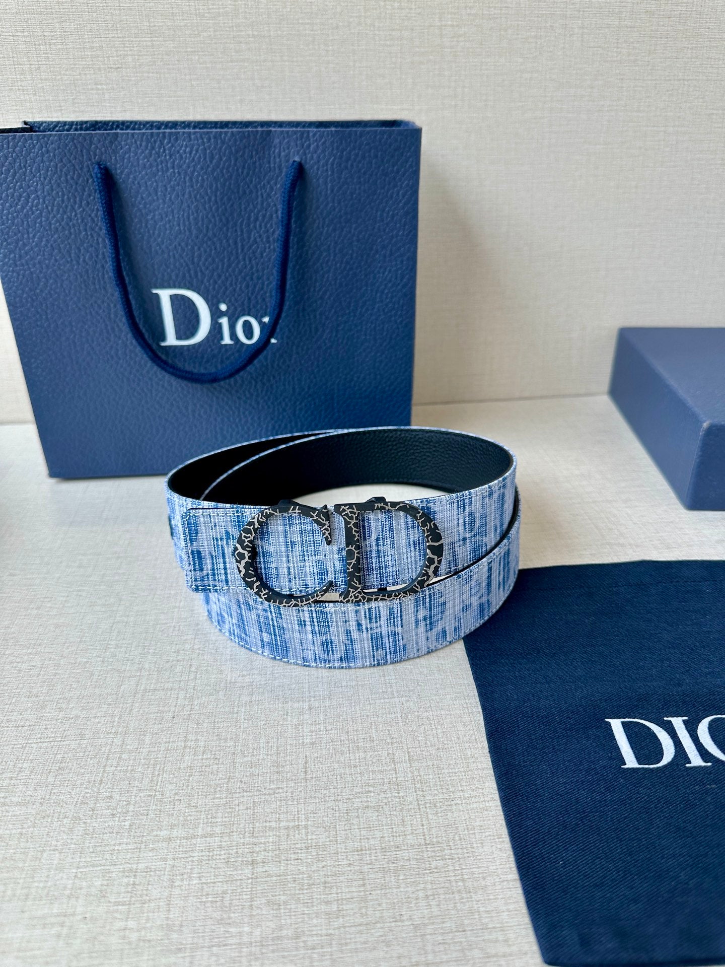 Dior belt with blue patterned strap and double-ring buckle on display