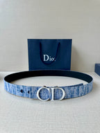 Blue fabric belt with silver-tone CD buckle and perforated strap holes.