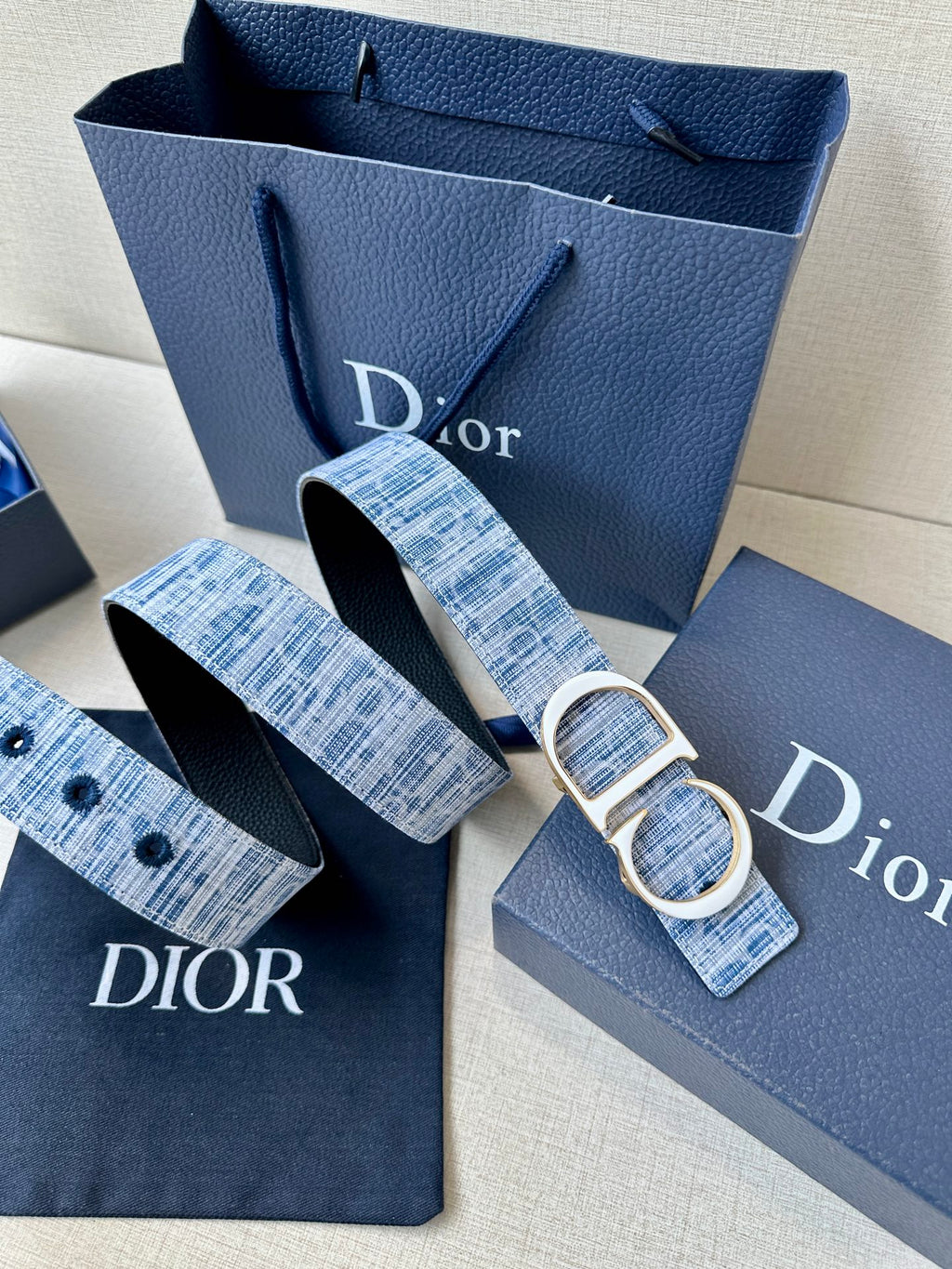 Blue plaid belt with silver CD buckle, plus matching strap ends and logo tabs.
