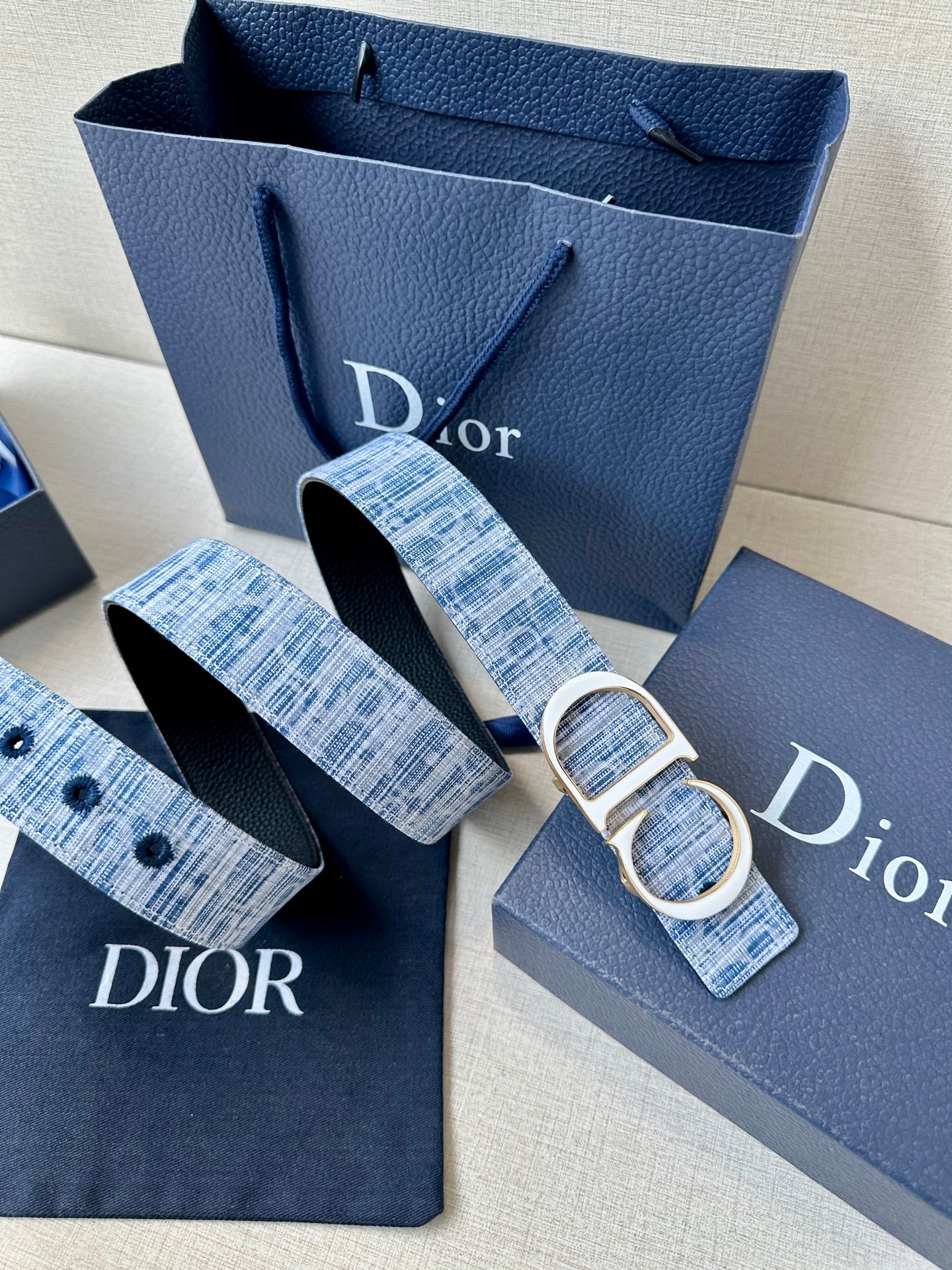 Blue plaid belt with silver CD buckle, plus matching strap ends and logo tabs.