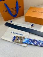 Louis Vuitton belt detail: blue monogram strap, gold-tone buckle, and adjustment holes.
