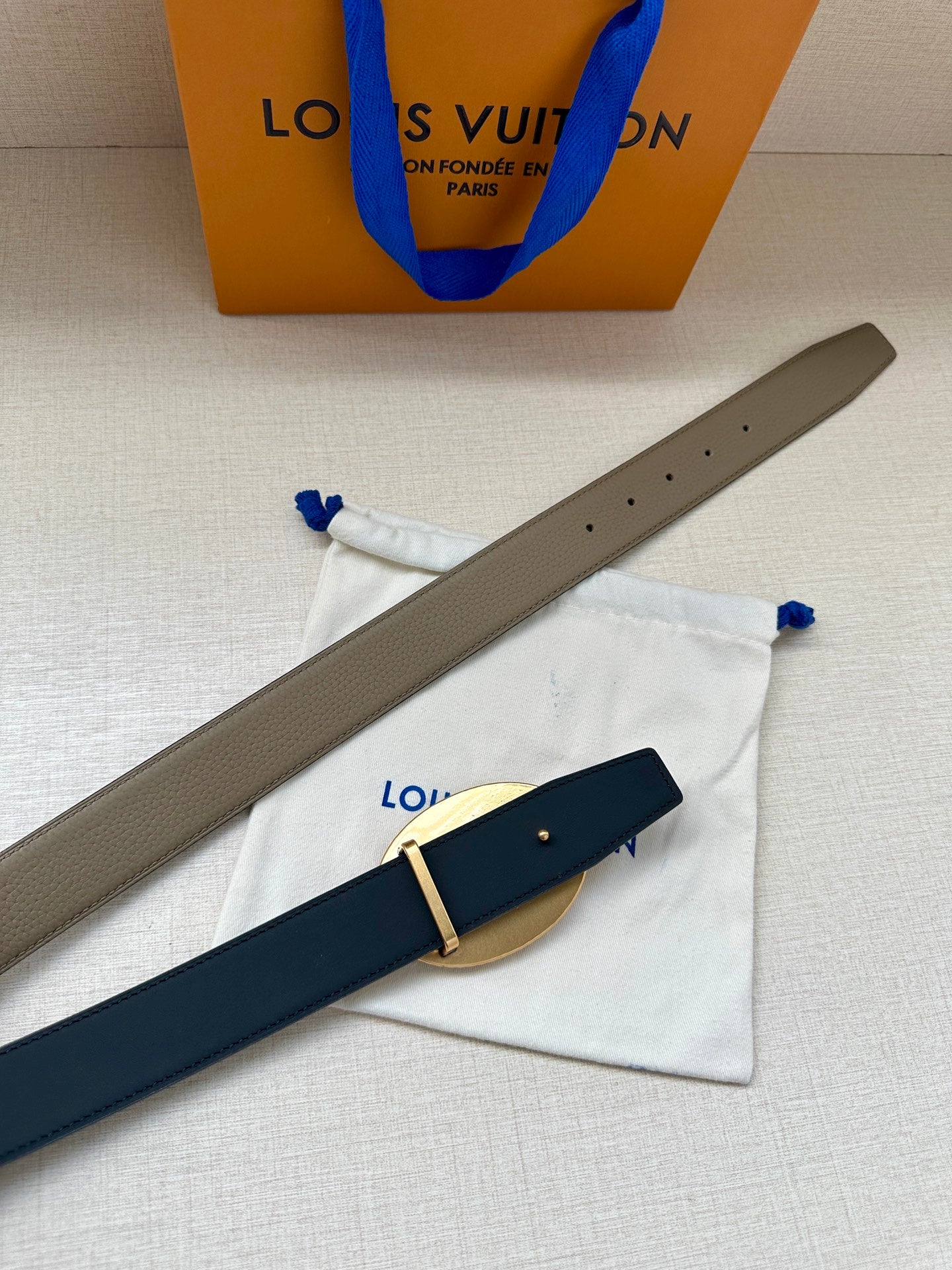 Louis Vuitton belt with beige and dark blue straps, oval gold buckle detail