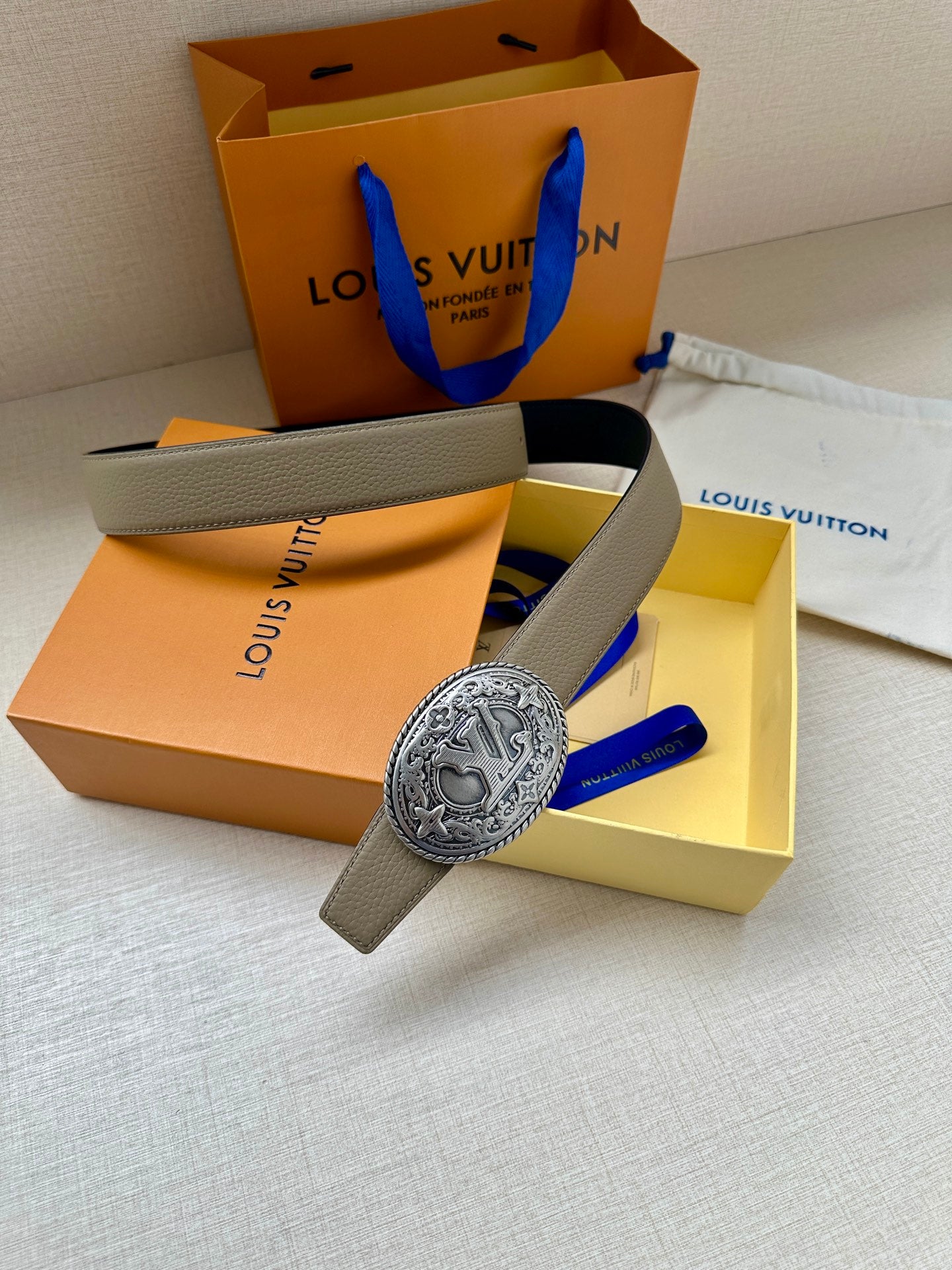Louis Vuitton belt with beige strap and large silver oval logo buckle, in box