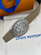 Louis Vuitton belt close-up: beige strap with silver oval logo buckle on pouch