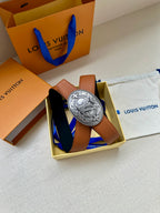 Brown leather belt with silver-tone oval logo buckle, shown in a box set