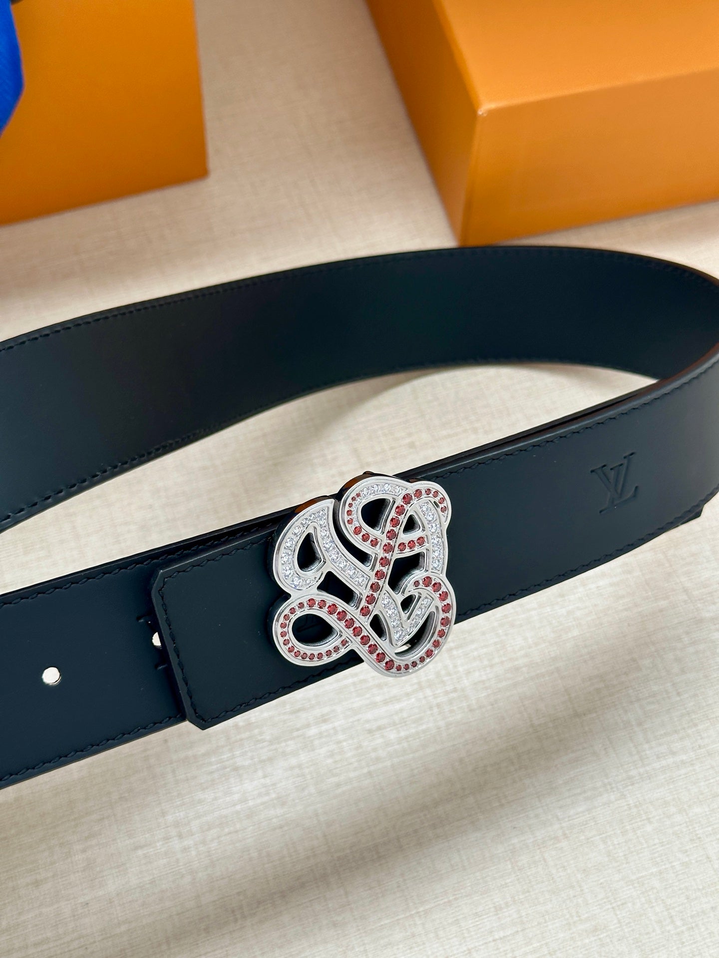 Louis Vuitton dark blue belt close-up of rhinestone monogram buckle