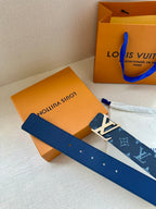 Navy monogram belt with silver grommets and gold-tone buckle on box