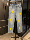 Light-wash denim pants with yellow cross patches, straight leg