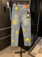 Light-wash denim pants with yellow cross patches, back view