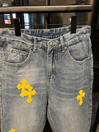 Light-wash denim jeans with yellow cross patches, waistband and pockets