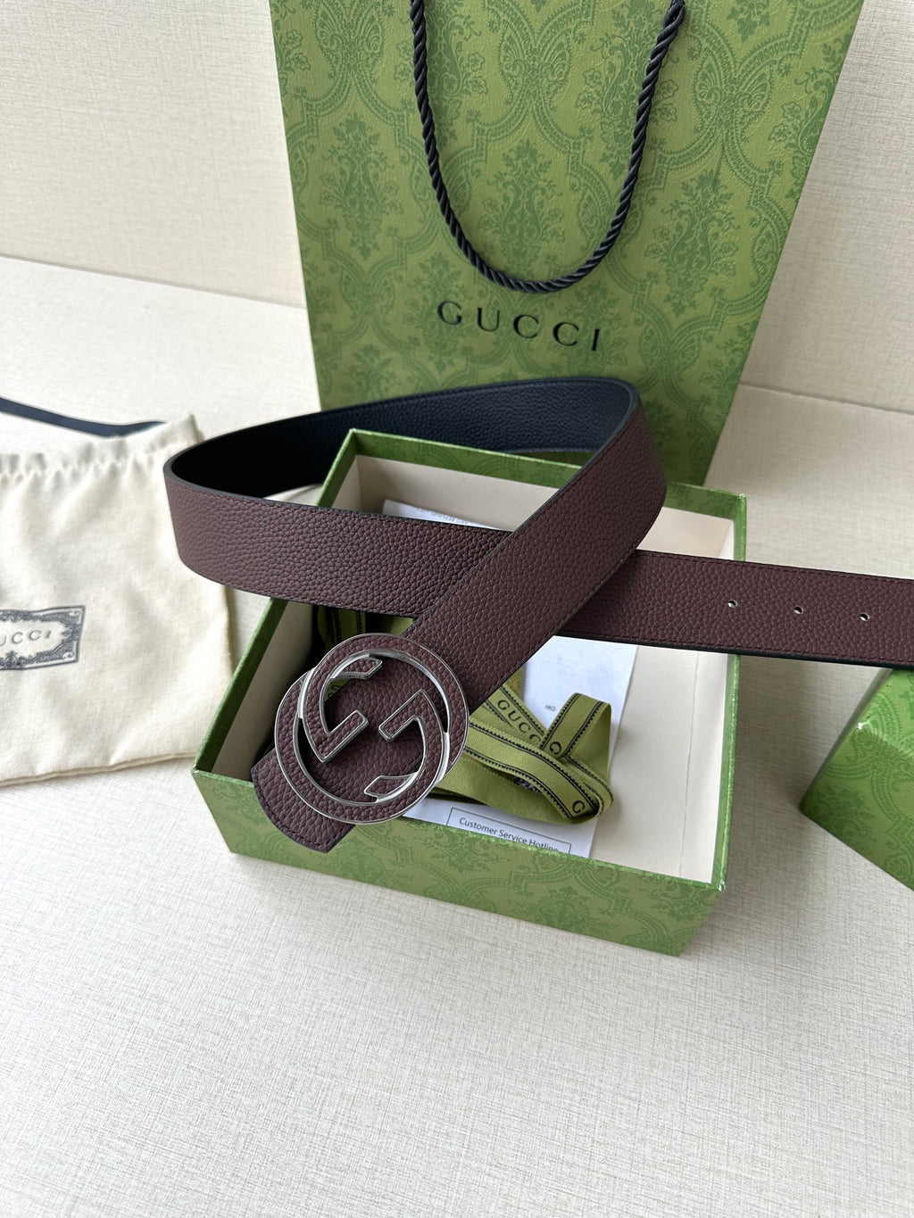 Brown leather belt with silver-tone interlocking G buckle, box display with card