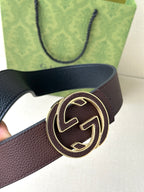 Gucci belt close-up: dark brown strap with gold-tone circular GG buckle