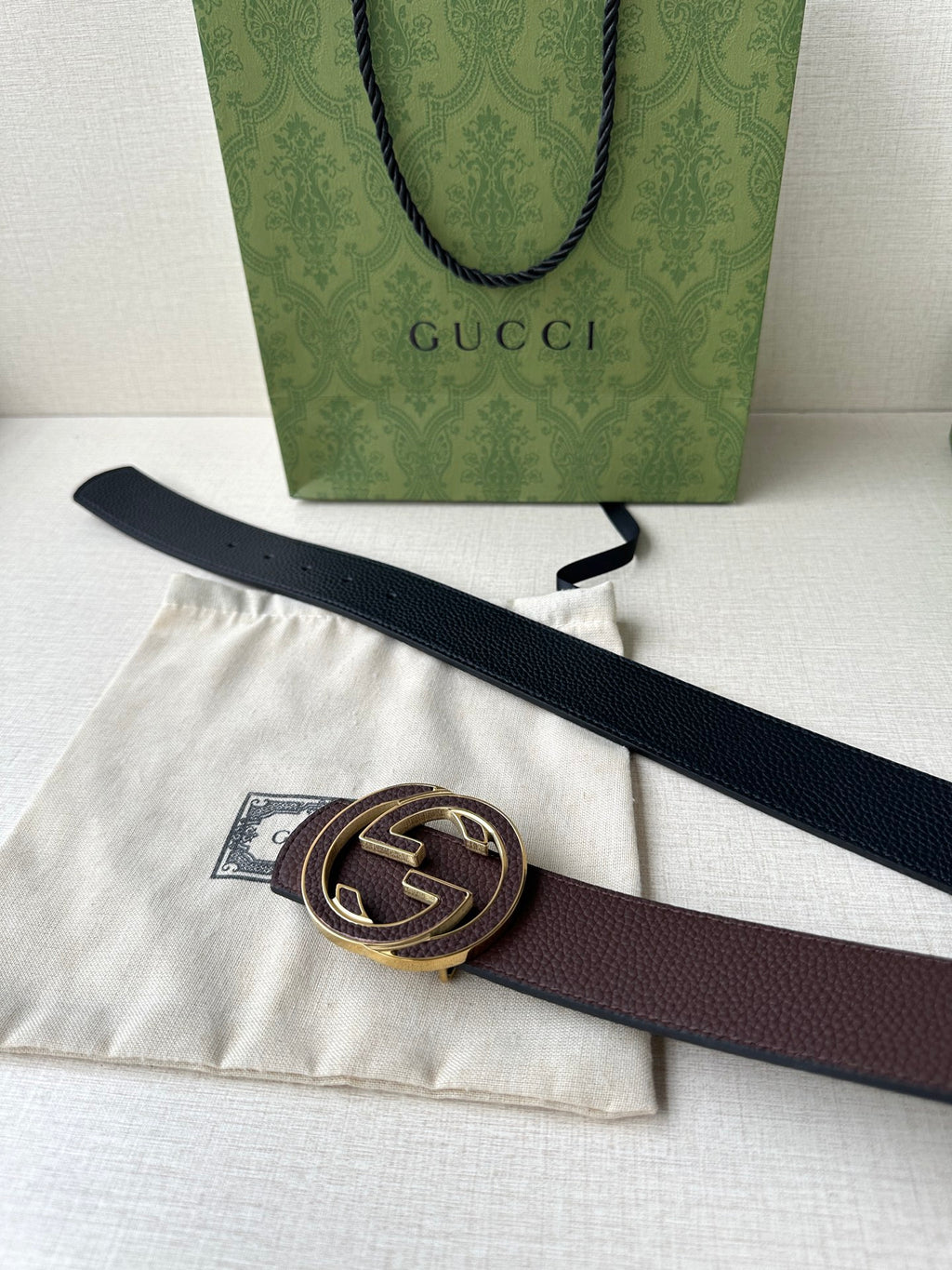 Gucci belt laid out with dark brown strap and gold-tone GG buckle