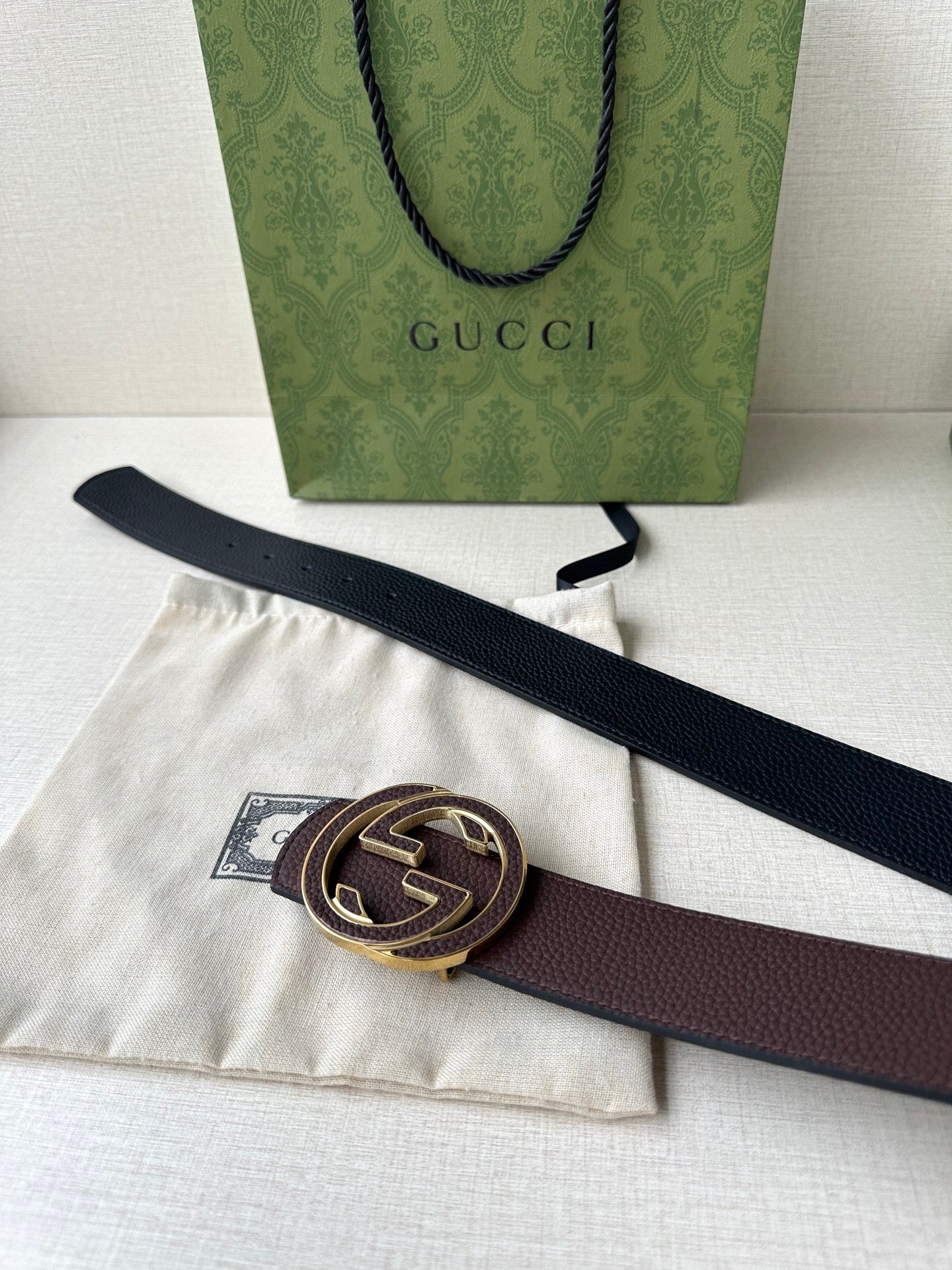 Gucci belt laid out with dark brown strap and gold-tone GG buckle