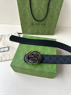 Gucci belt with gold-tone double G buckle across Gucci shopping bag