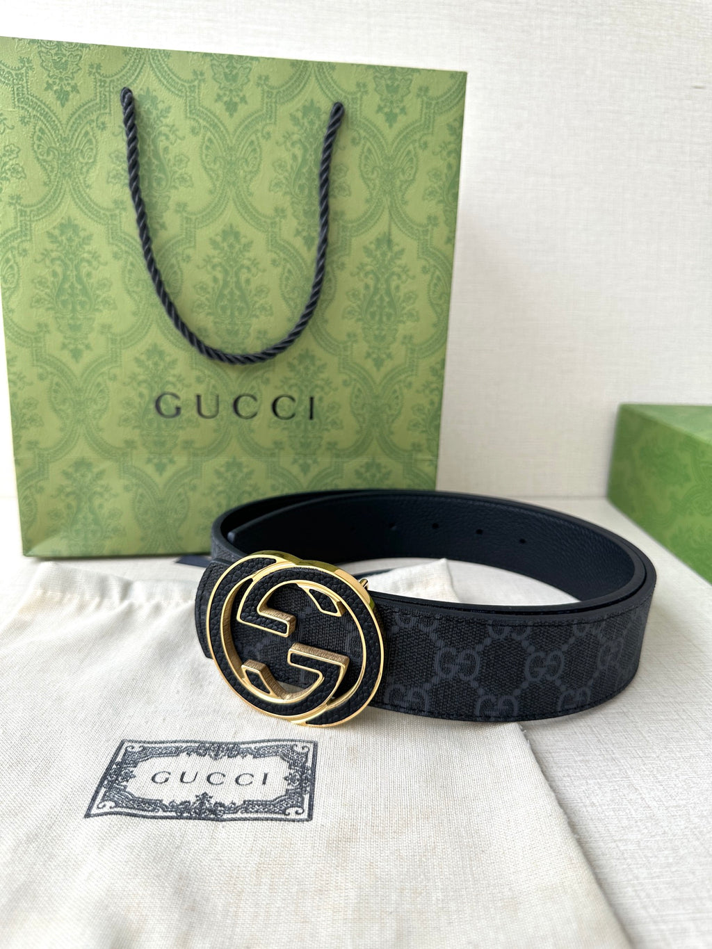 Gucci belt laid flat on tissue with gold-tone double G buckle and Gucci tag