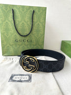 Gucci belt laid flat on tissue with gold-tone double G buckle and Gucci tag