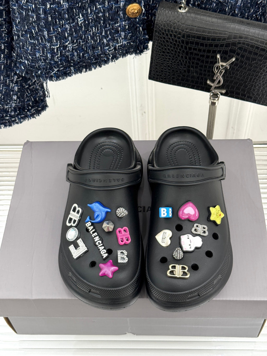 Black platform slide sneakers with multicolor charm accents and molded straps