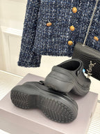 Black platform slide sneakers with thick tread sole and rear strap
