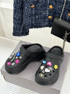 Black slide sneakers on display with colorful letter-and-star charm accents