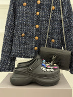 Black platform slide sneakers with front strap and decorative charm patches