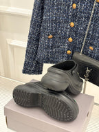 Balenciaga black slip-on clogs with front charms, heel and outsole visible