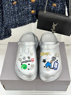 Silver clog shoes with colorful sticker charms and textured side strap