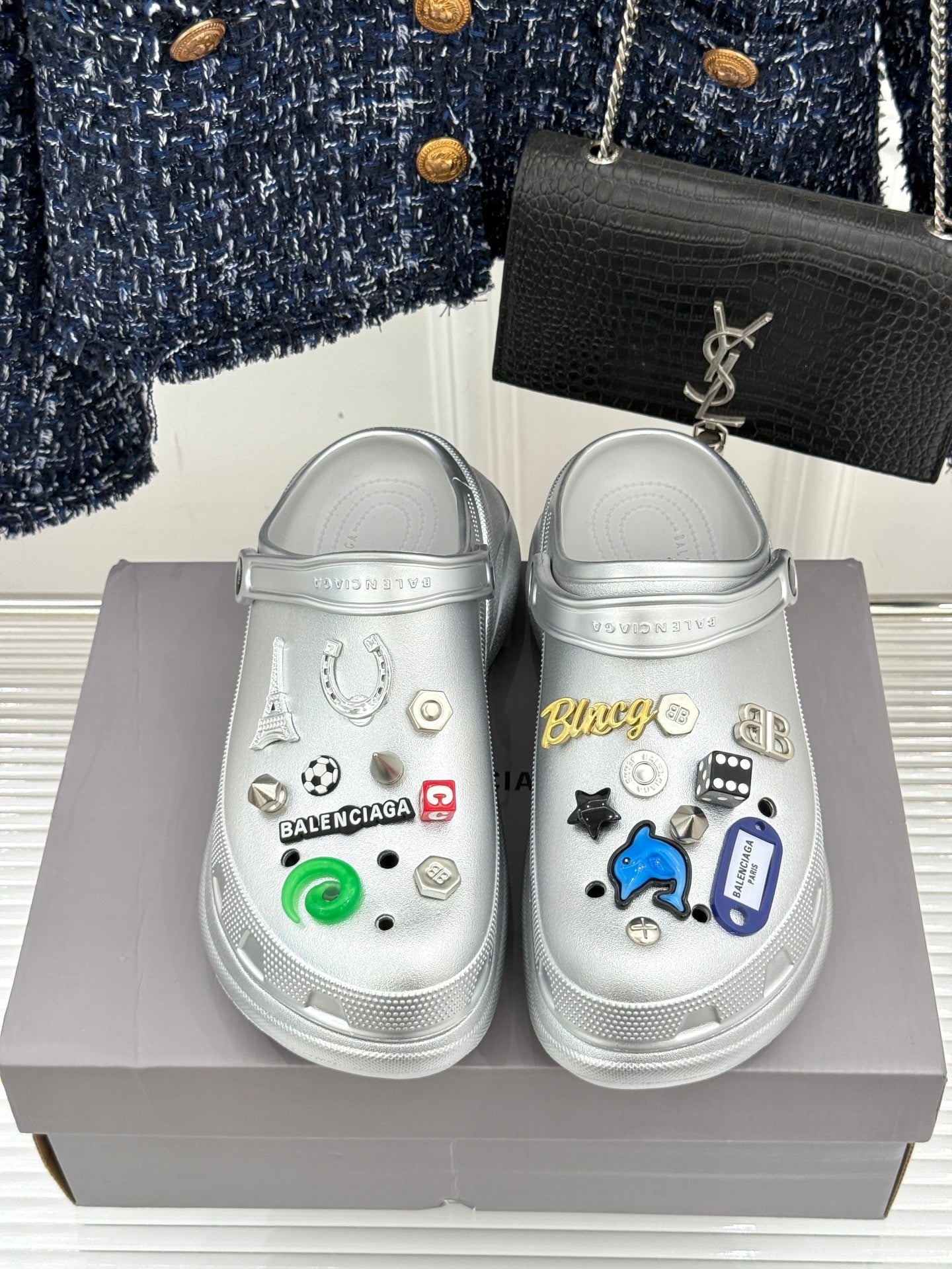 Silver clog shoes with colorful sticker charms and textured side strap