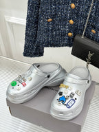 Silver clog shoes with sticker charms and star detail on top