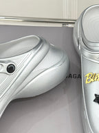 Silver slip-on clog shoes with smooth textured finish and curved sole