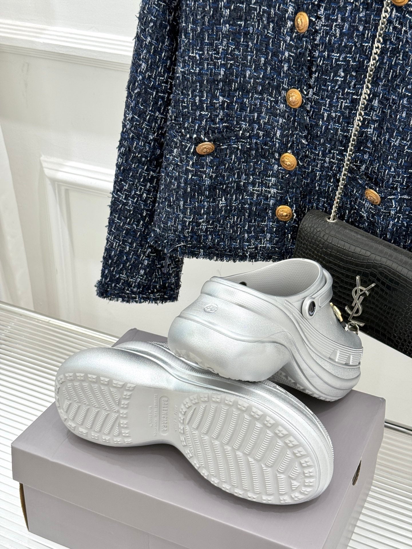 White platform clog shoes on a box with chunky tread soles
