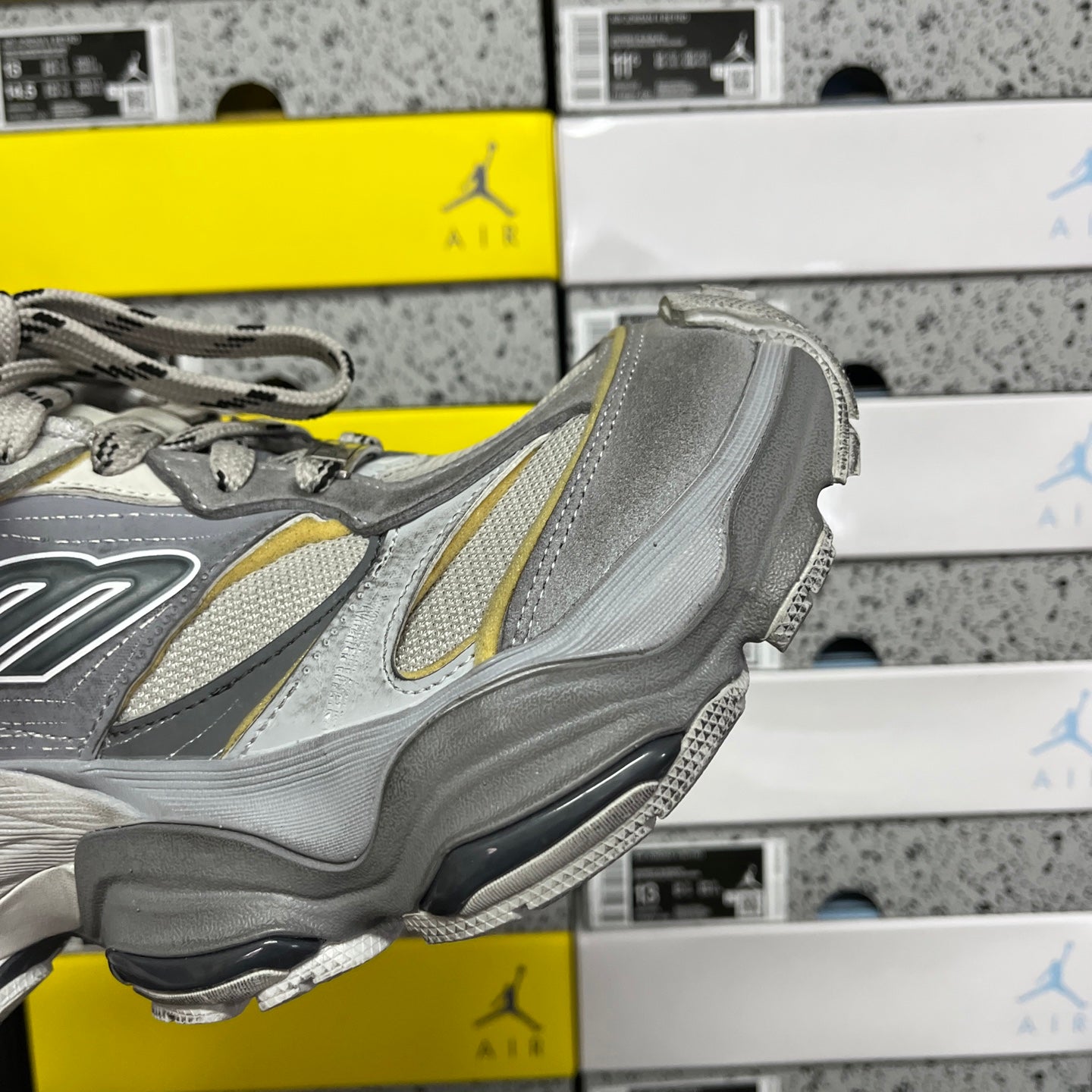 Gray Balenciaga sneaker side view with yellow-trim detail and textured sole